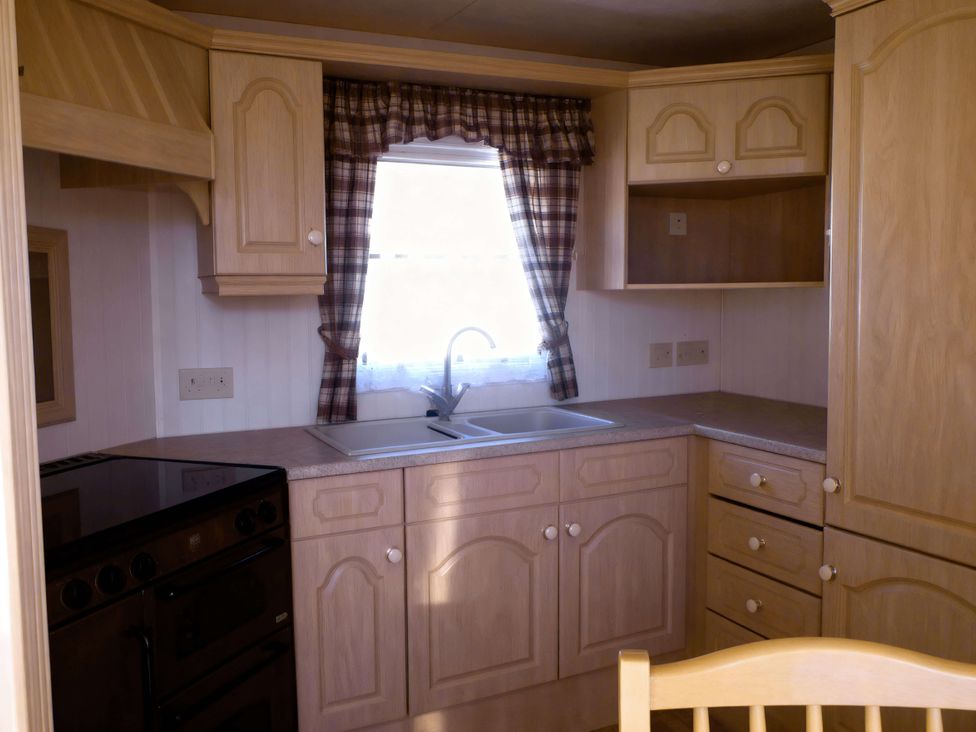 A kitchen with a sink and stove at Coastfield Holiday Village - Holiday Accommodation 2604 in Ingoldmells