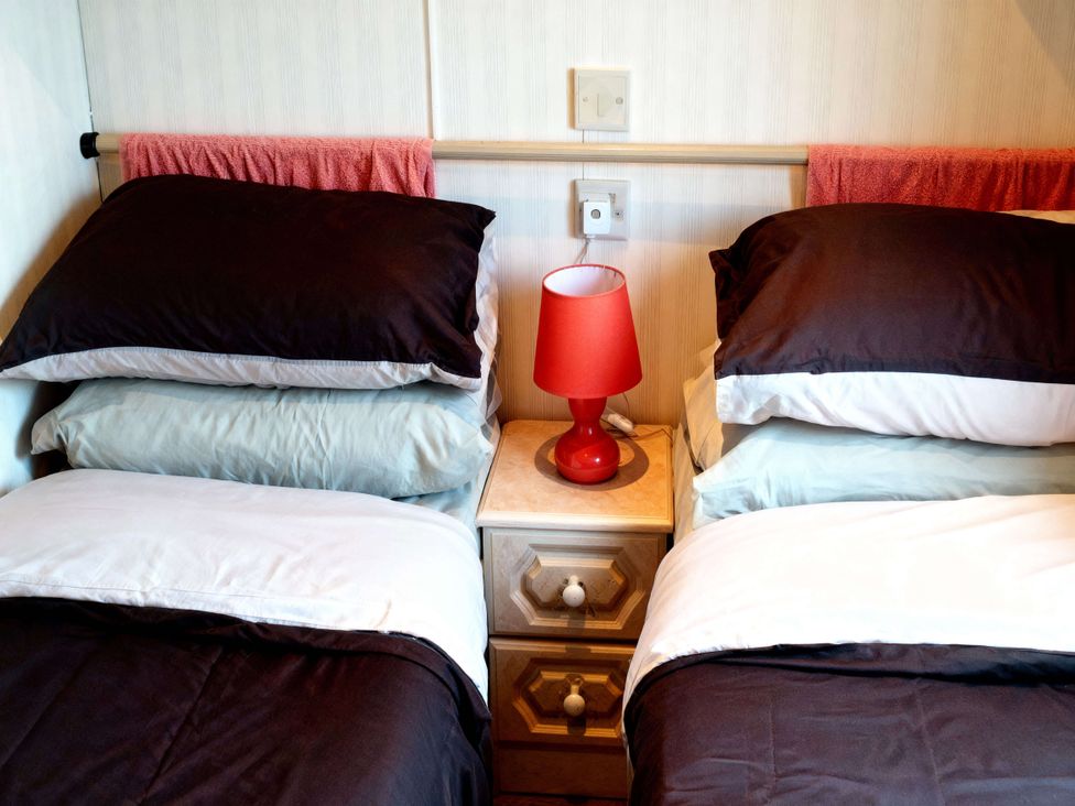 A bedroom with two beds and a lamp at Coastfield Holiday Village - Holiday Accommodation 2604 in Ingoldmells
