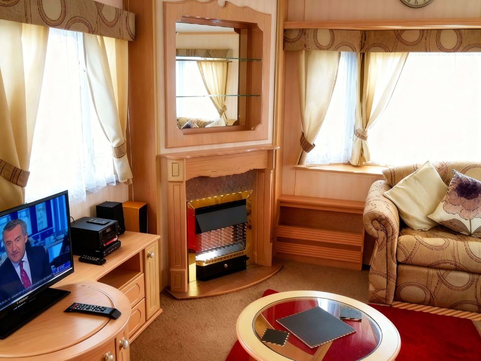 A living room with a television and fireplace at Coastfield Holiday Village - Holiday Accommodation 2604 in Ingoldmells