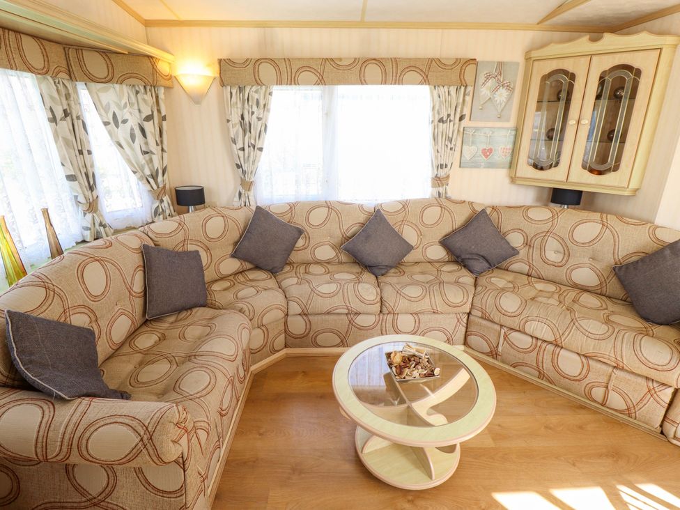 A living room with a corner sofa and coffee table at Coastfield Holiday Village - Holiday Accommodation 2604 in Ingoldmells