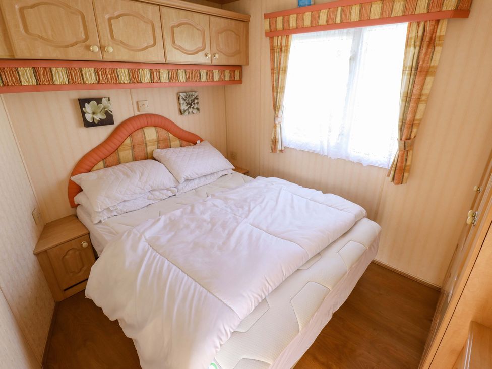 A bedroom with a bed and furniture at Coastfield Holiday Village - Holiday Accommodation 2604 in Ingoldmells