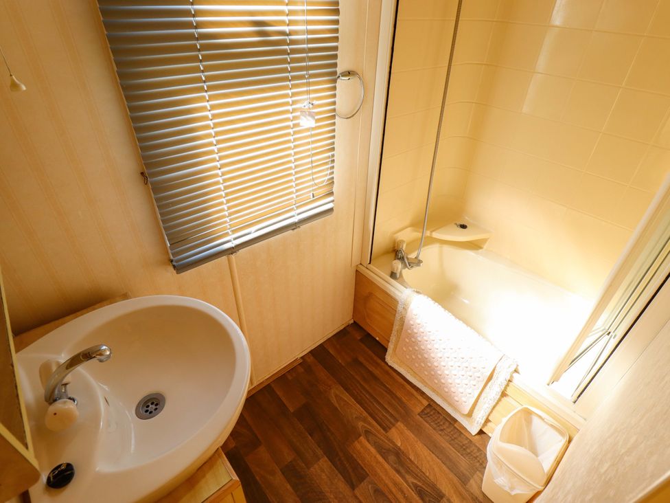 A bathroom featuring a sink and a bath tub at Coastfield Holiday Village - Holiday Accommodation 2604 in Ingoldmells