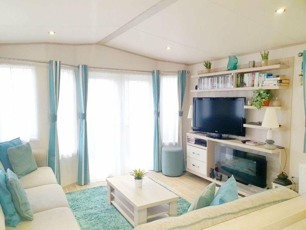 a living room with a TV and seating area at Shorefield Country Park - Holiday Accommodation 3042 in Milford On Sea