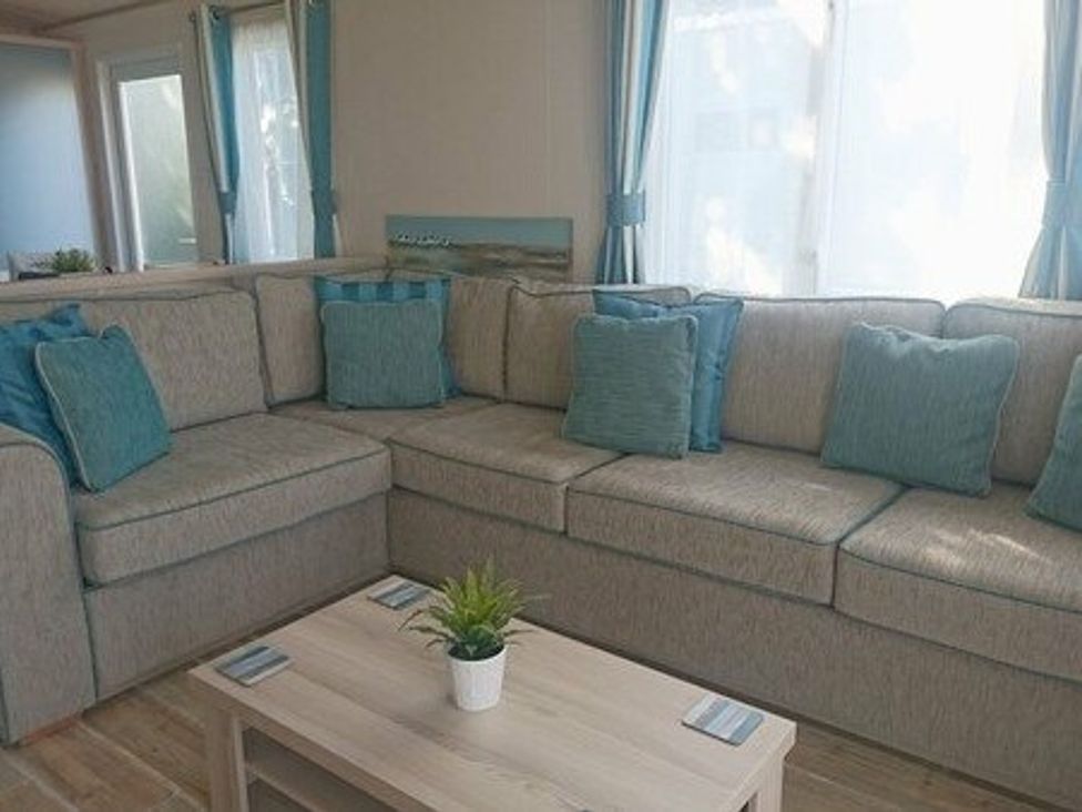a seating area with a sectional sofa and a coffee table at Shorefield Country Park - Holiday Accommodation 3042, Milford On Sea