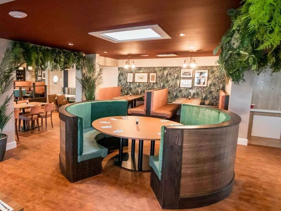 a restaurant interior with booth seating and green decor at Shorefield Country Park - Holiday Accommodation 3042 Milford On Sea