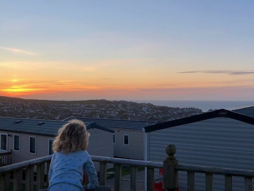 a child looking at a sunset over a caravan park at Liskey Hill Caravan Park - Holiday Accommodation 3043 Perranporth