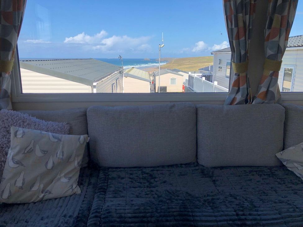 a sofa with cushions and a view of the sea at Liskey Hill Caravan Park - Holiday Accommodation 3043 Perranporth