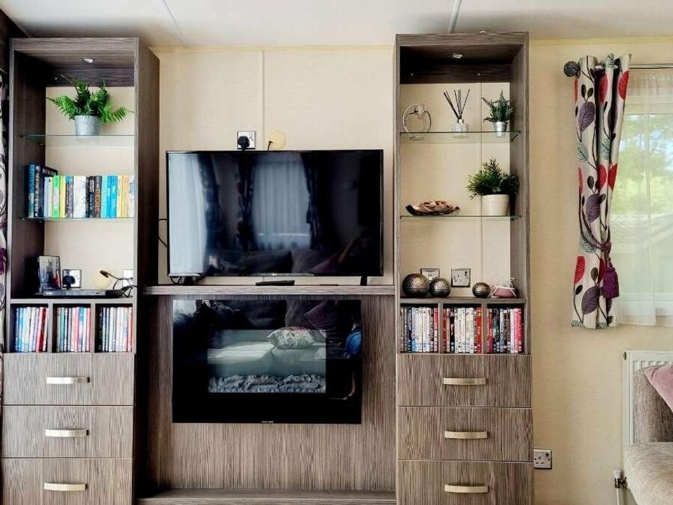 a living room with a television and storage units at Shorefield Country Park - Holiday Accommodation 4132 in Milford On Sea