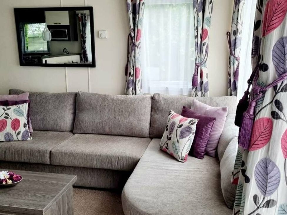 a living room with a grey sectional sofa and decorative cushions at Shorefield Country Park - Holiday Accommodation 4132, Milford On Sea