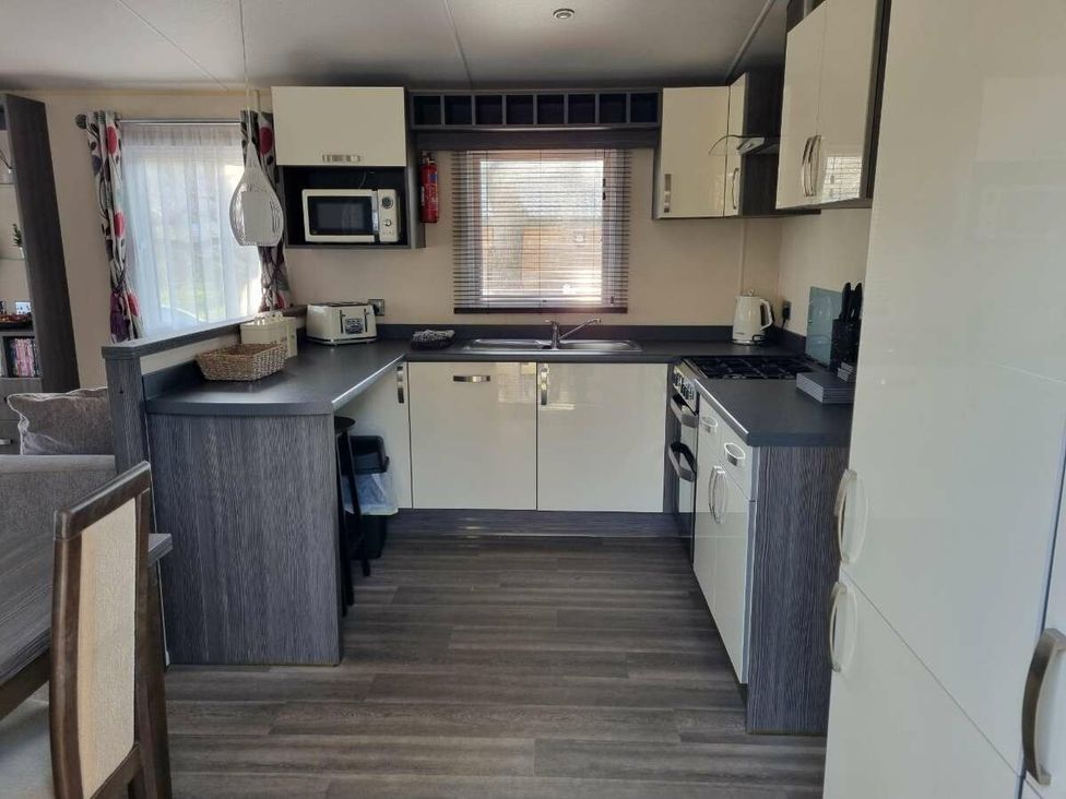 a kitchen with integrated appliances and a dining area at Shorefield Country Park - Holiday Accommodation 4132, Milford On Sea
