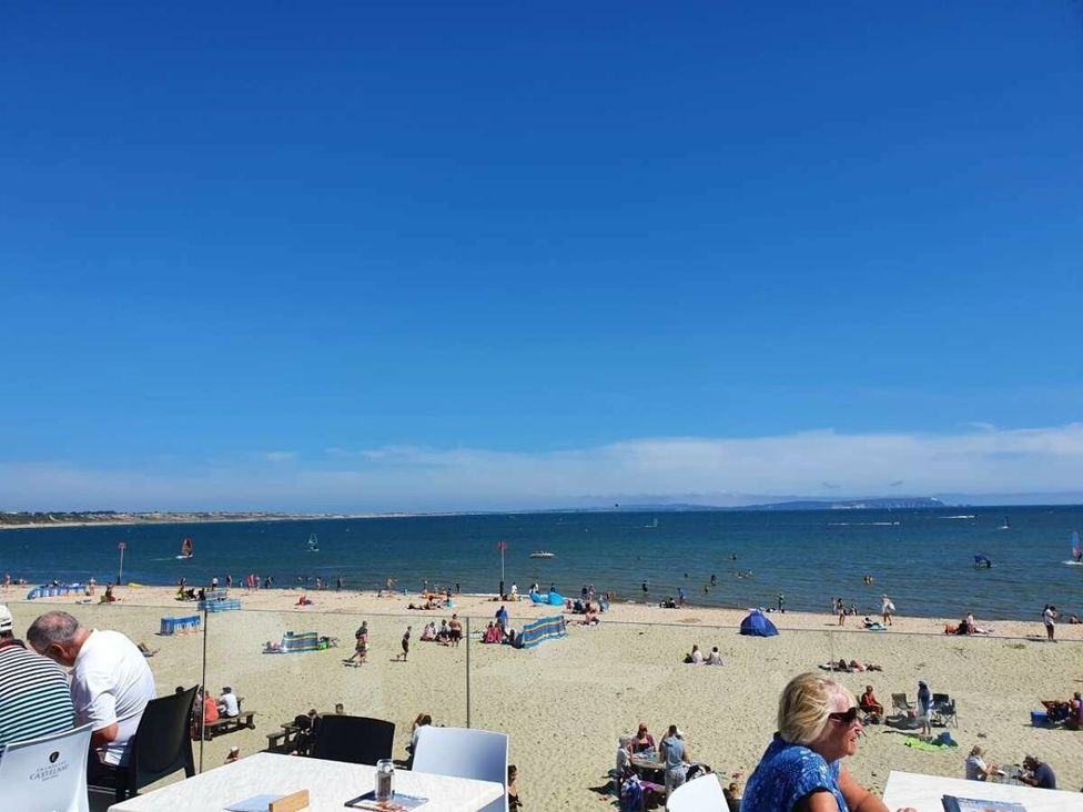 a beach scene with people sunbathing and water activities at Shorefield Country Park - Holiday Accommodation 4132 in Milford On Sea