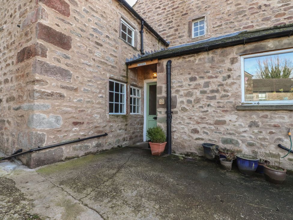 An outdoor area with a door and stone walls at The Snug in Morecambe