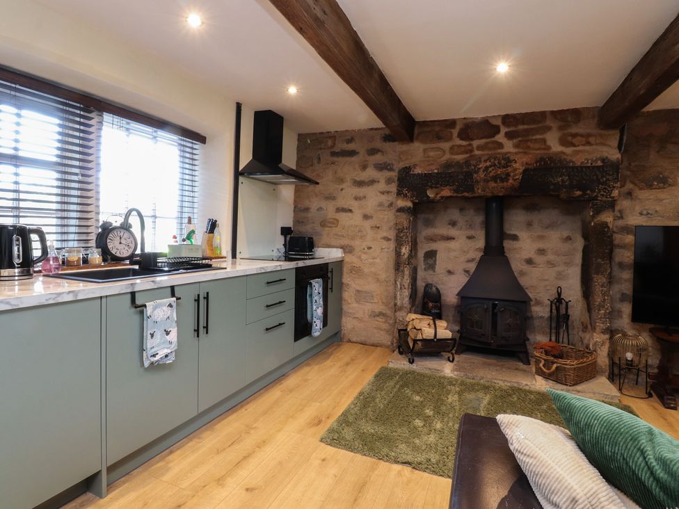A kitchen with appliances and a fireplace at The Snug in Morecambe