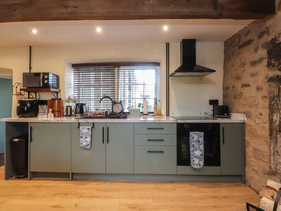A kitchen with appliances and a countertop at The Snug in Morecambe