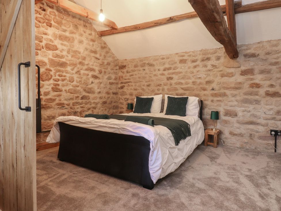 A bedroom with a bed and stone walls at The Snug in Morecambe
