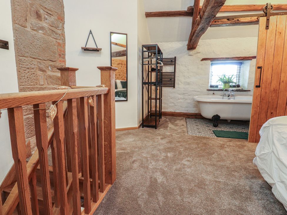 A bathroom with a bathtub and shelving unit at The Snug in Morecambe