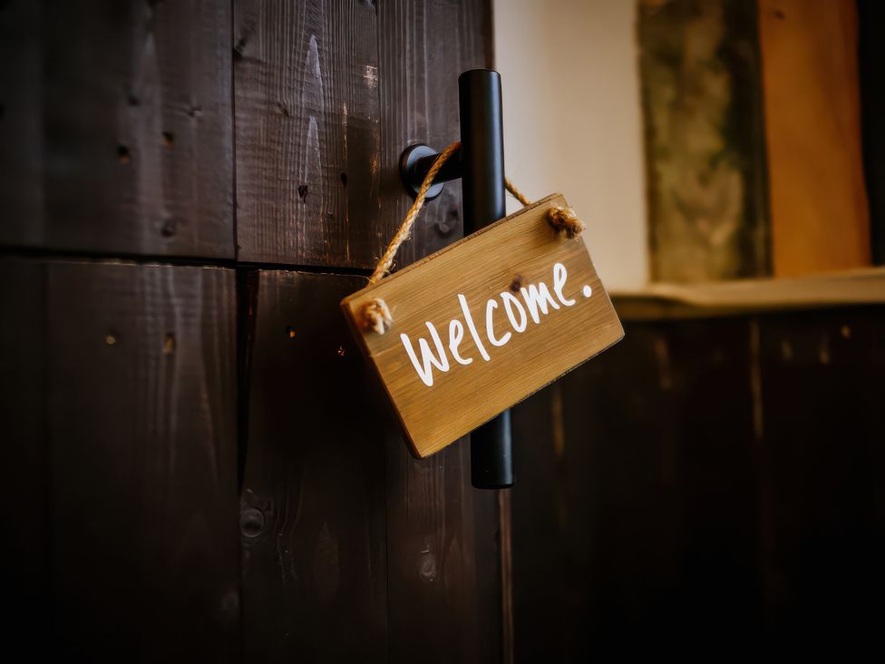 A welcome sign hanging on a door at The Snug in Overton near Heysham
