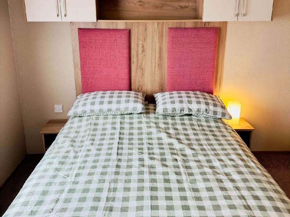 a bed with a checked green and white bedspread at St Andrews Holiday Park - Holiday Accommodation 609, St. Andrews