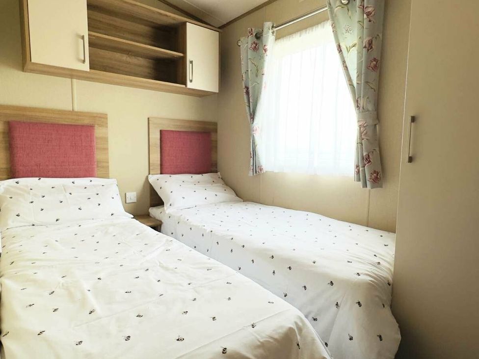 a bedroom with two single beds and a window with curtains at St Andrews Holiday Park - Holiday Accommodation 609, St. Andrews