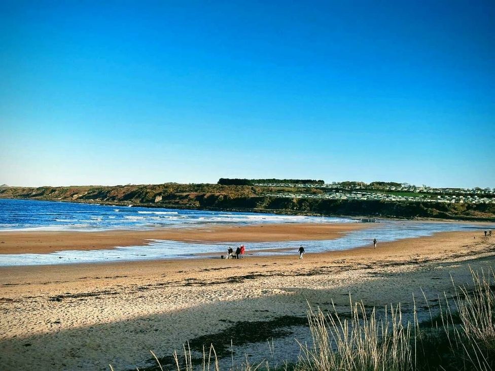 a beach with people walking along the shoreline at St Andrews Holiday Park - Holiday Accommodation 609 St. Andrews