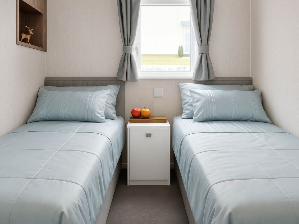 A bedroom with two beds and a bedside table at Hopton Holiday Village - Holiday Accommodation 632 Great Yarmouth
