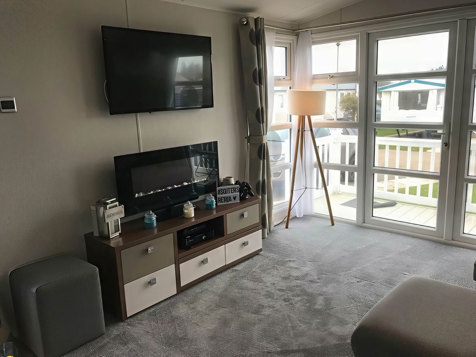 A living room with a television and a fireplace at Hopton Holiday Village - Holiday Accommodation 632 Great Yarmouth
