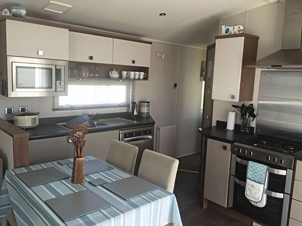 A kitchen with appliances and dining area at Hopton Holiday Village - Holiday Accommodation 632 Great Yarmouth