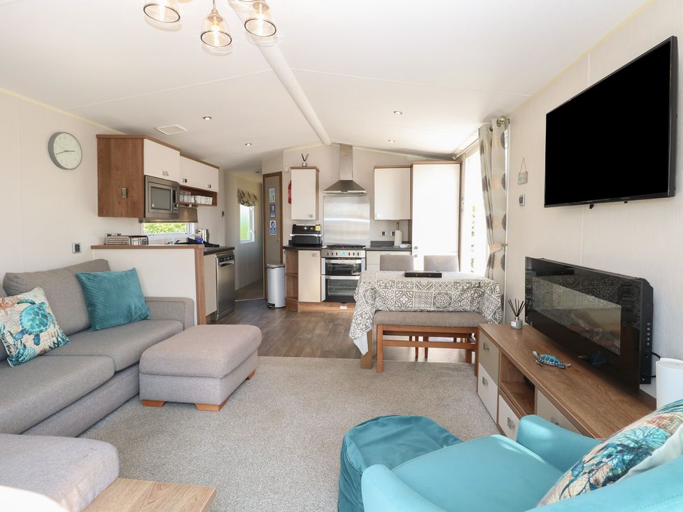 A living room with a sofa and dining area at Hopton Holiday Village - Holiday Accommodation 632 Hopton-On-Sea