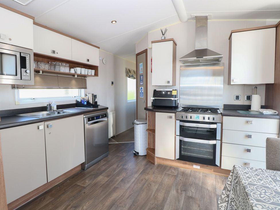A kitchen with appliances and cabinetry at Hopton Holiday Village - Holiday Accommodation 632 Hopton-On-Sea