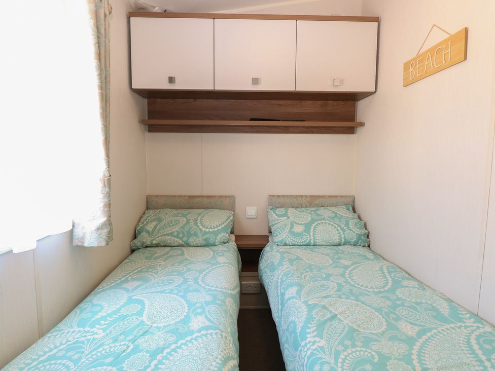 A bedroom with two beds and storage at Hopton Holiday Village - Holiday Accommodation 632 Hopton-On-Sea
