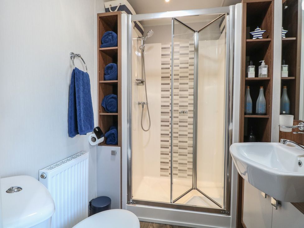 A bathroom with a shower, toilet, sink, and towels at Hopton Holiday Village - Holiday Accommodation 632 Hopton-On-Sea