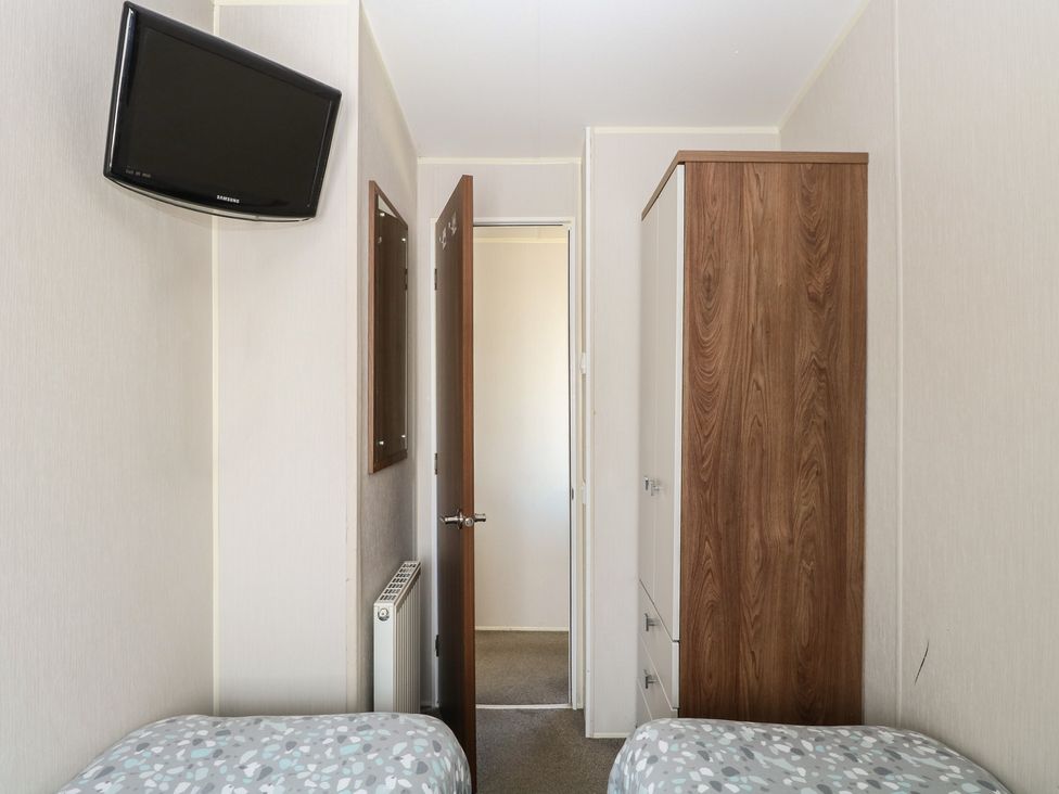 A bedroom with a television and wardrobe at Hopton Holiday Village - Holiday Accommodation 632 Hopton-On-Sea