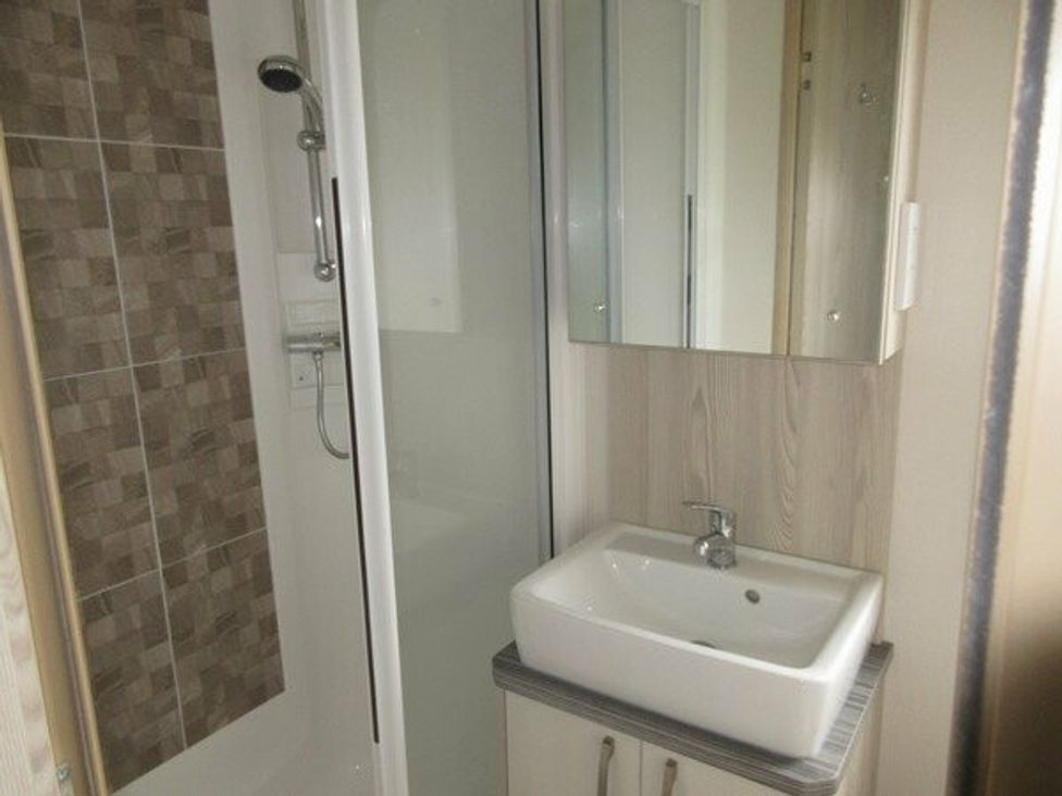 a bathroom with a shower and sink unit at Durdle Door Holiday Park - Holiday Accommodation 6617, Wareham