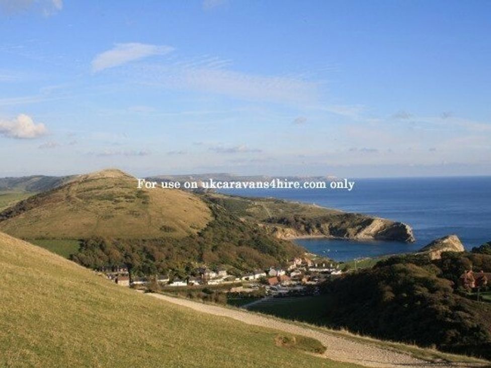 a coastal view with hills and a bay at Durdle Door Holiday Park - Holiday Accommodation 6617 Wareham