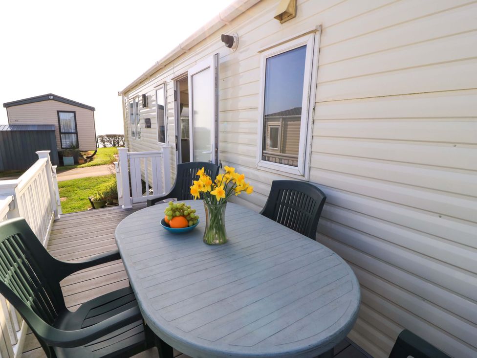 An outdoor seating area with a table and chairs at Beachcombers in Wareham