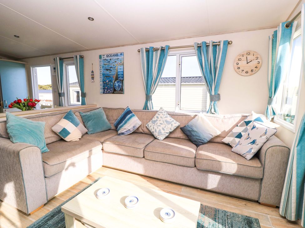 A living room with a sofa and a coffee table at Beachcombers in Wareham
