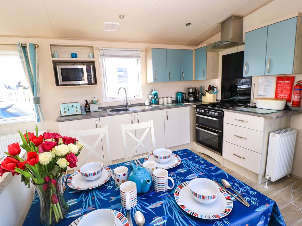 A kitchen with appliances and dining setup at Beachcombers in Wareham