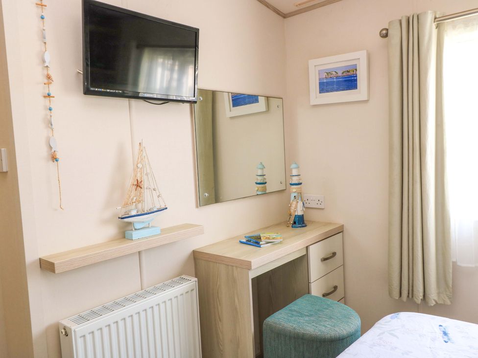 A bedroom with a desk and decorations at Beachcombers in Wareham