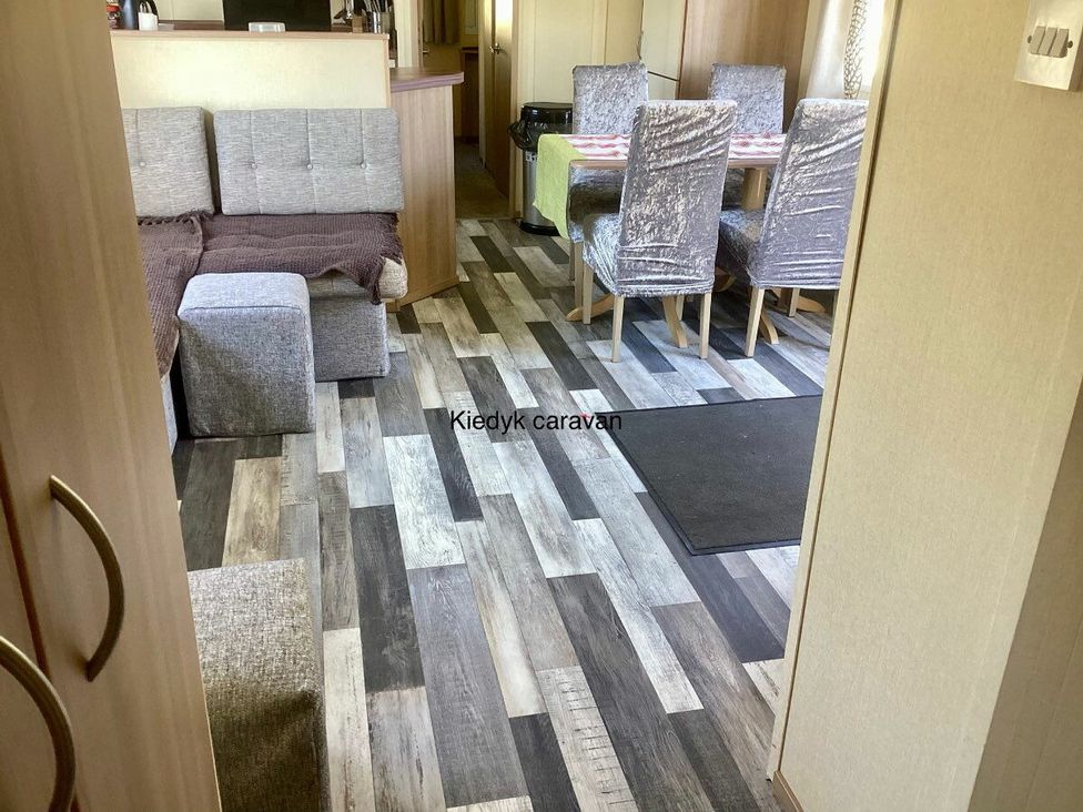 a living area with sofas and dining chairs at KiedyK caravan in Skegness