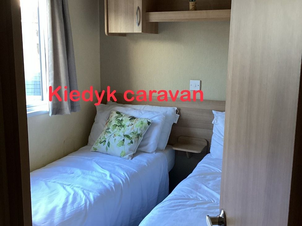a small bedroom with two single beds at KiedyK caravan in Skegness