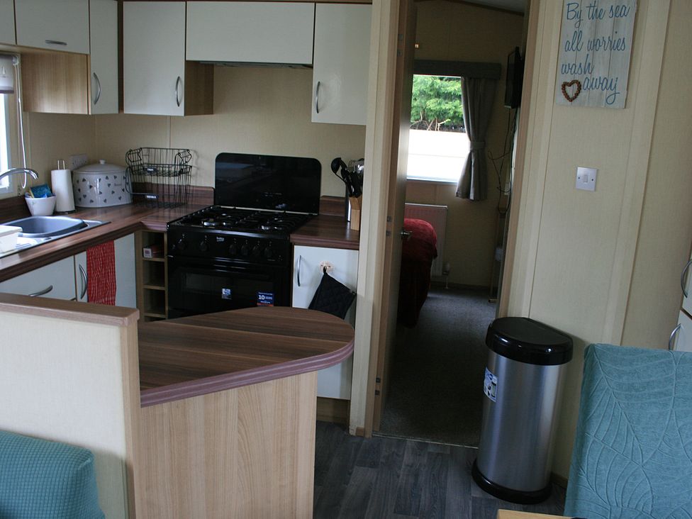 A kitchen with a gas stove and sink at Southview Holiday Park 7251 Skegness