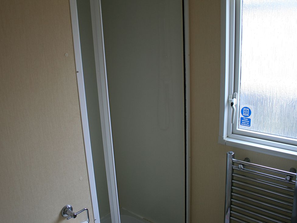 A bathroom with a shower and towel rail at Southview Holiday Park 7251 Skegness