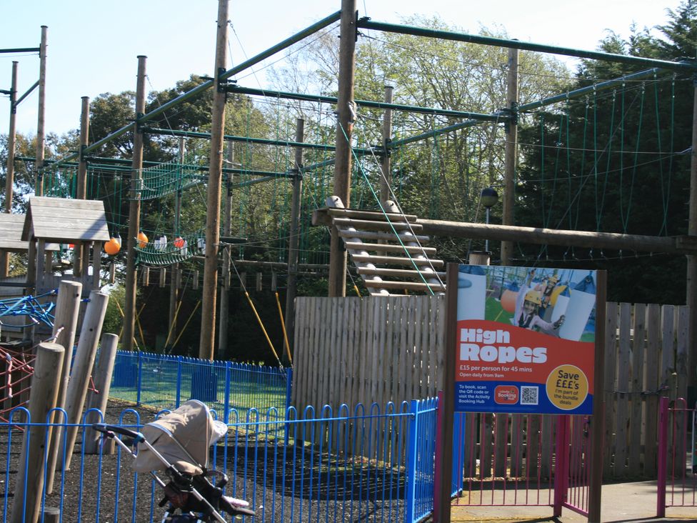 An outdoor high ropes course with a safety sign and playground equipment at Southview Holiday Park 7251 Skegness
