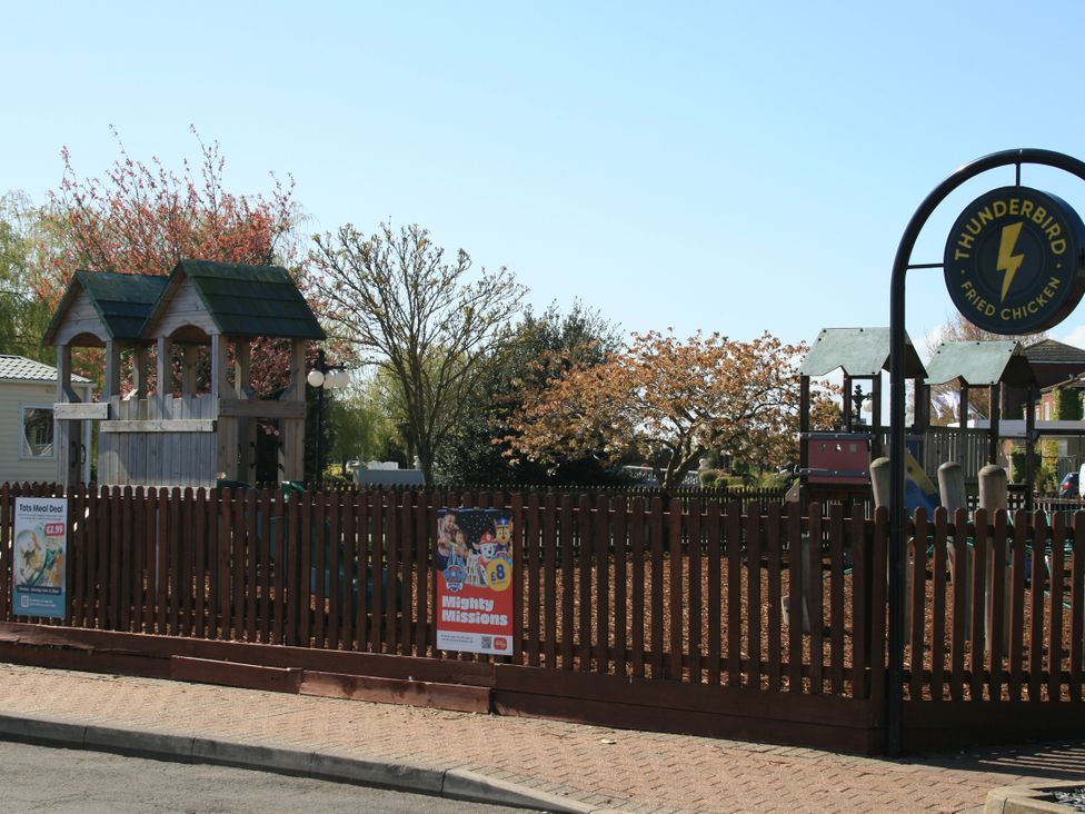 A playground with a structure and signs at Southview Holiday Park 7251 Skegness