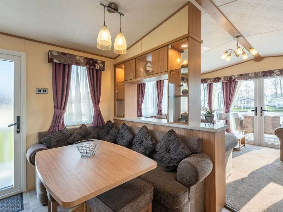 a dining area with a table and cushioned seating at Haggerston Castle - Holiday Accommodation 779 in Berwick-upon-Tweed