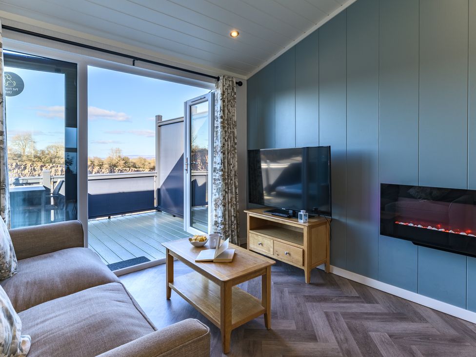 A living room with a television and sliding door at Coniston in Penrith