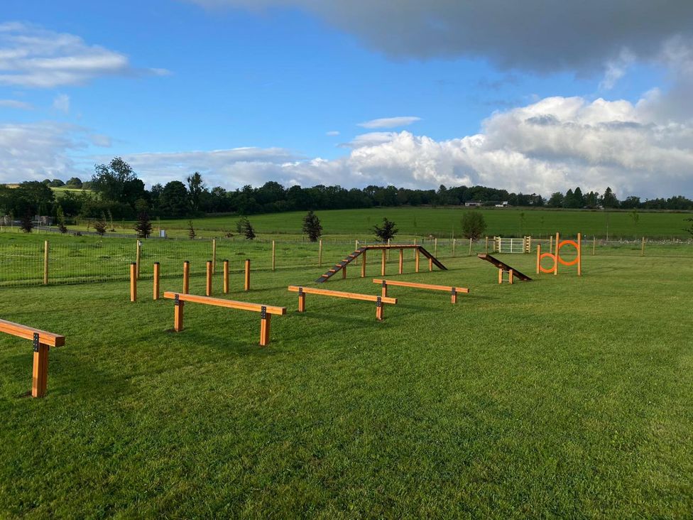 An outdoor agility course with obstacles in a grassy area at Coniston in Penrith
