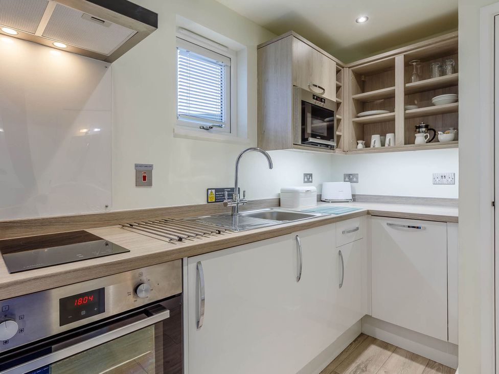 A kitchen with oven and microwave at Lakeside Studio in Portreath