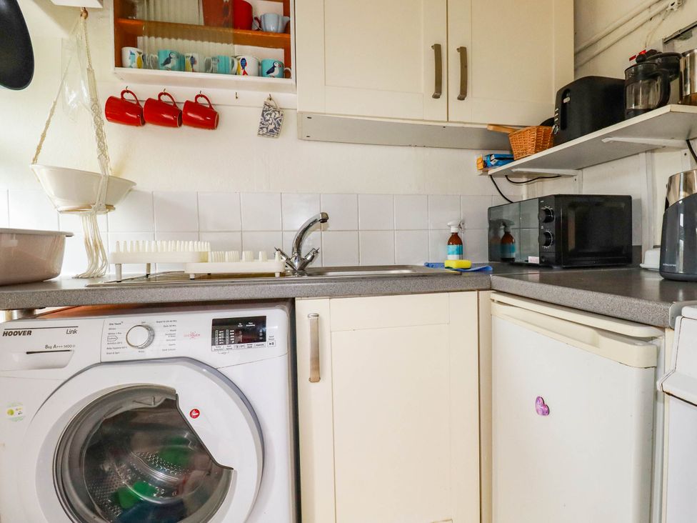 A kitchen with a sink, washing machine, microwave, and fridge at Harford