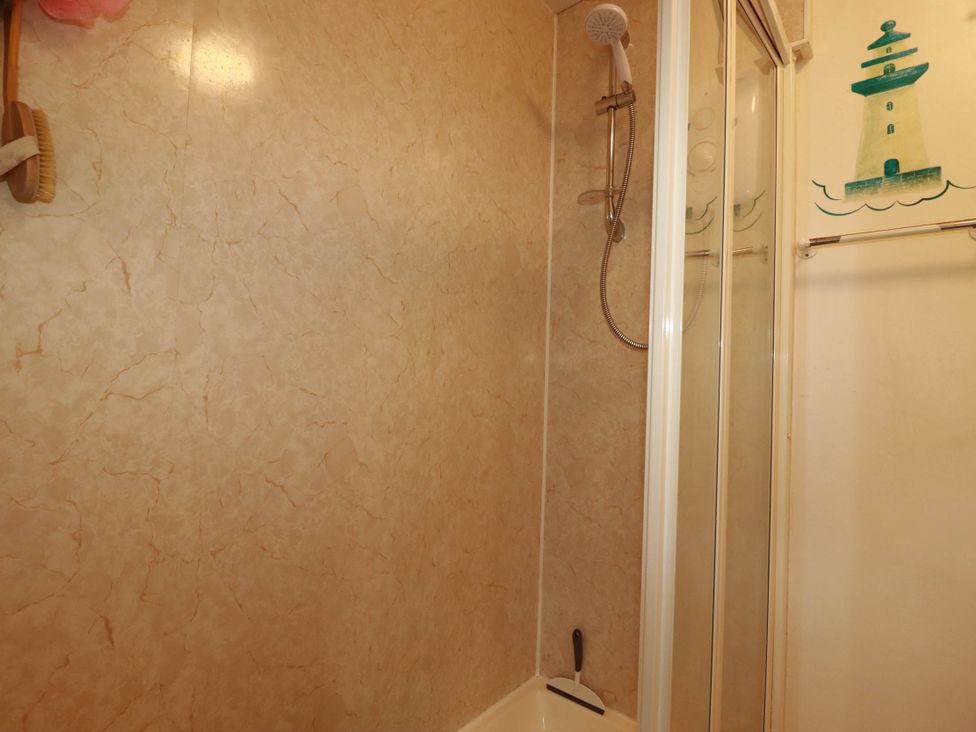A shower with a curtain and towel rack at Harford